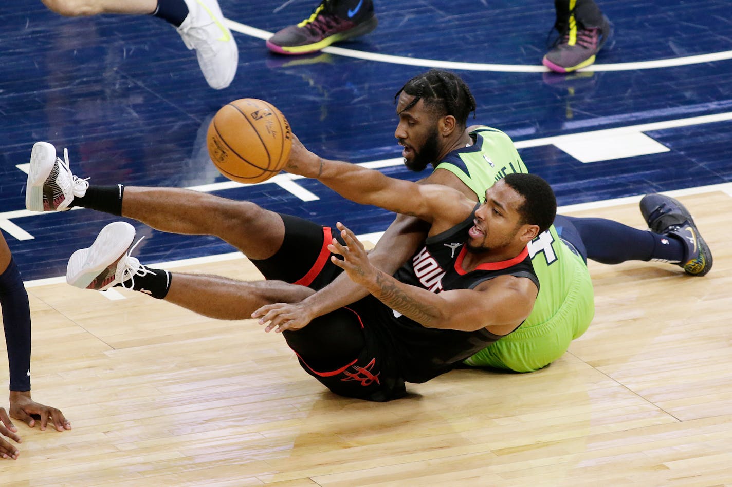 Houston Rockets forward Sterling Brown (0) passes the ball after getting it from Minnesota Timberwolves guard Jaylen Nowell (4) during the third quarter during an NBA basketball game Saturday, March 27, 2021, in Minneapolis. (AP Photo/Andy Clayton-King)