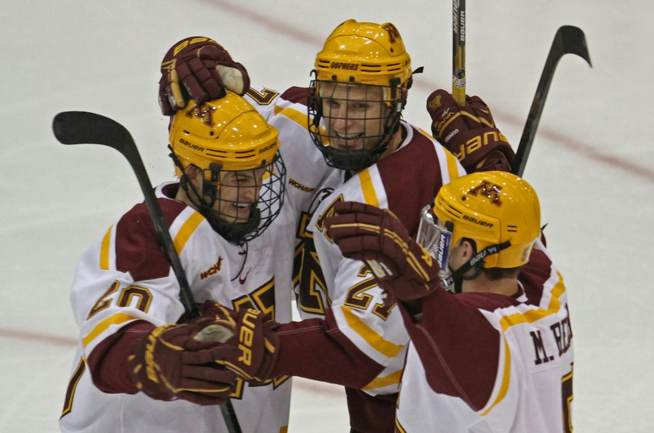 Minnesota's Nick Bjugstad celebrated a first-period goal with (left) Mark Alt and (right) Mike Reilly earlier this season.