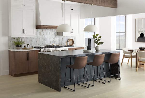 Quartz and quartzite countertops, wood grain cabinets and statement hoods are popular trends for the kitchen. The island is painted the soft black Cra