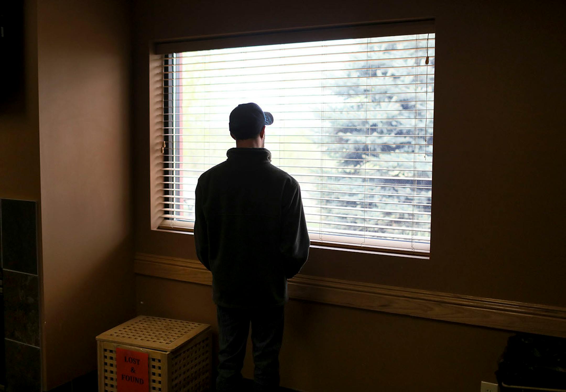 Chris McIntire looks out a window at at a day training and habilitation center where he spends part of his day Friday, May 11, 2018, in Big Lake, MN.