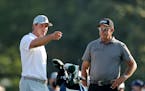 Bryson DeChambeau, left, talks with Phil Mickelson on the 10th tee during a practice round for the Masters