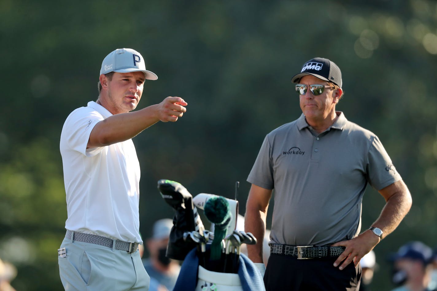 Bryson DeChambeau, left, talks with Phil Mickelson on the 10th tee during a practice round for the Masters