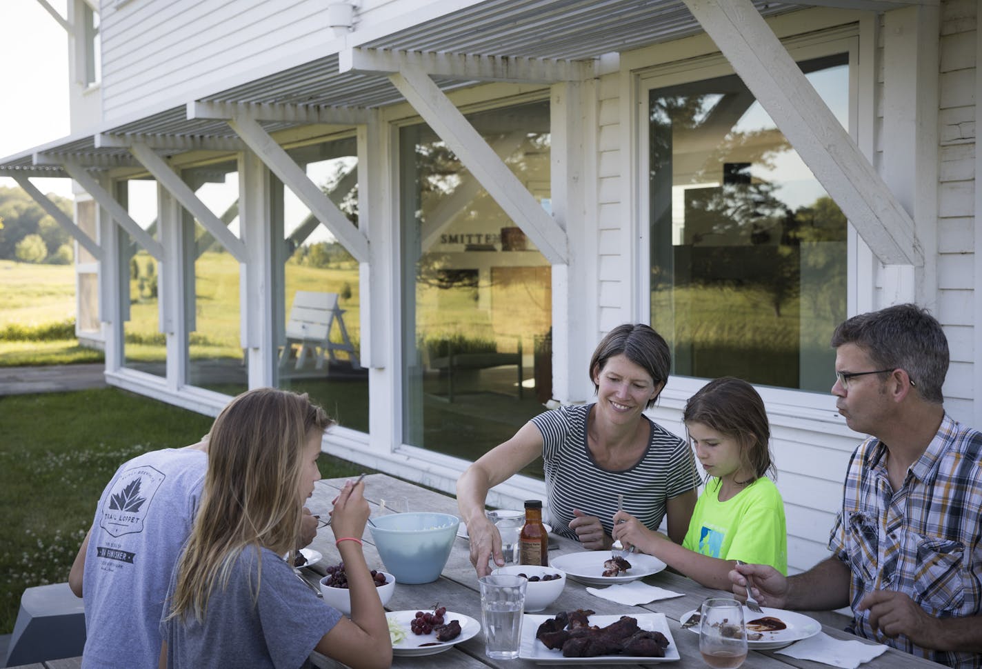 The Smitten family ate dinner in their backyard at Jackson Meadow, top, a conservation development in Marine on St. Croix.