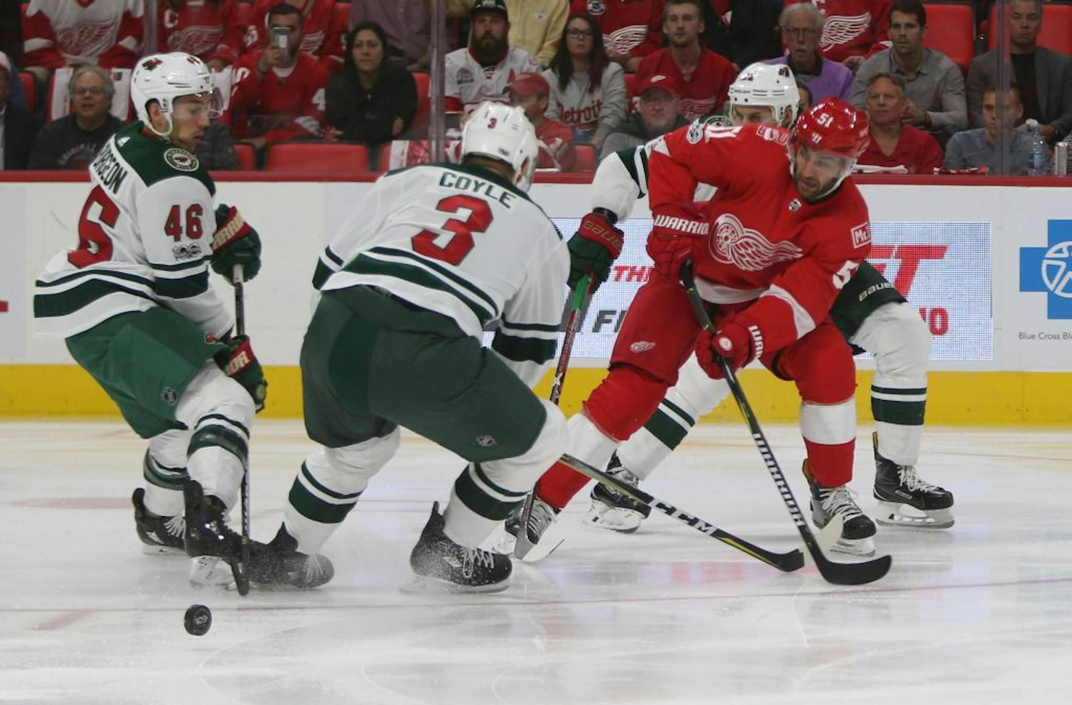 The Detroit Red Wings' Frans Nielsen, right, shoots against the Minnesota Wild's Charlie Coyle and Jared Spurgeon during first period action at Little Caesars Arena in Detroit on Thursday, Oct. 5, 2017.