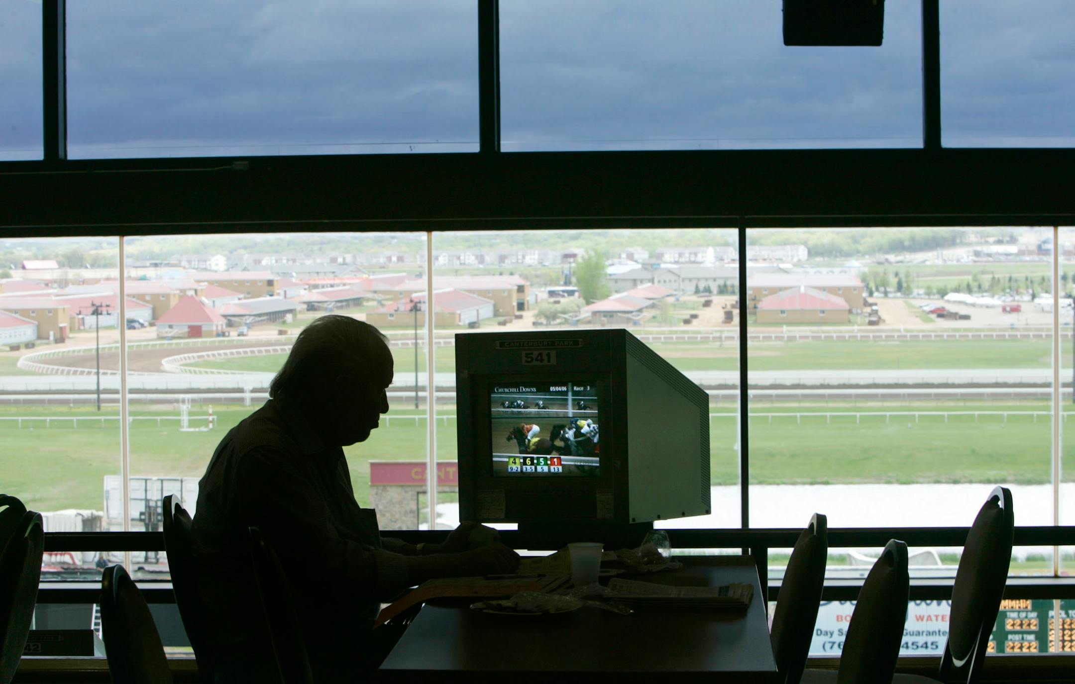 Albert Kemmer of Savage studies a TV screen after placing a bet on a horse race Thursday, May 4, 2006, at the simulcast center at Canterbury Park in Shakopee.