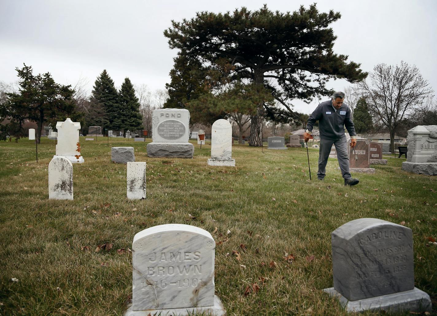 Erick Perez Flores removed grave marking poles in the pioneer section of the Bloomington Cemetery Wednesday April 23 , 2014 in Bloomington, MN. ] JERRY HOLT jerry.holt@startribune.com