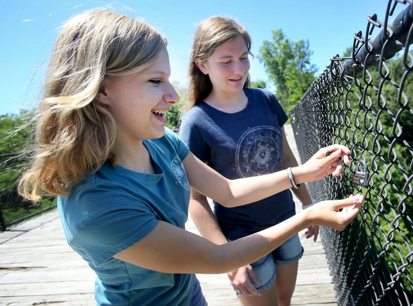 Friends Sidney Cater, left, and Emily Meyer, both 15, from Hastings, add a lock to the &#xec;Love locks&#xee; that adorn a chain link fence over the Vermillion Gorge Bridge in Hastings .and the bridge gradually grows The bridge grows heavier by the day and was seen Tuesday, June 21, 2016, in Hastings, MN. The one they added was also a tribute to their new friend Adrianna Mendyka, 17, who had recently left after being an exchange student in Hastings.](DAVID JOLES/STARTRIBUNE)djoles@startribune Th