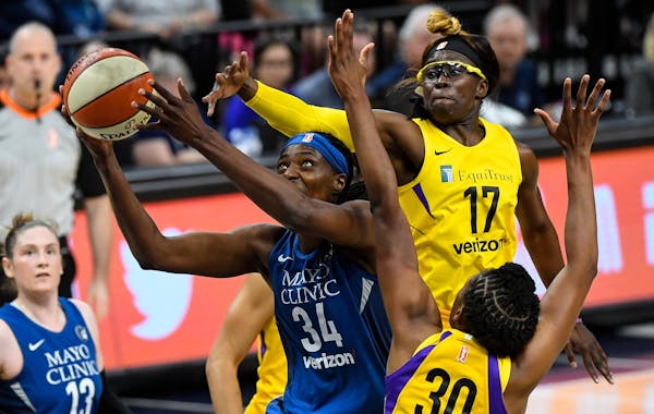 Minnesota Lynx center Sylvia Fowles (34) powered through the defense of Los Angeles Sparks forward Essence Carson (17) and forward Nneka Ogwumike (30)