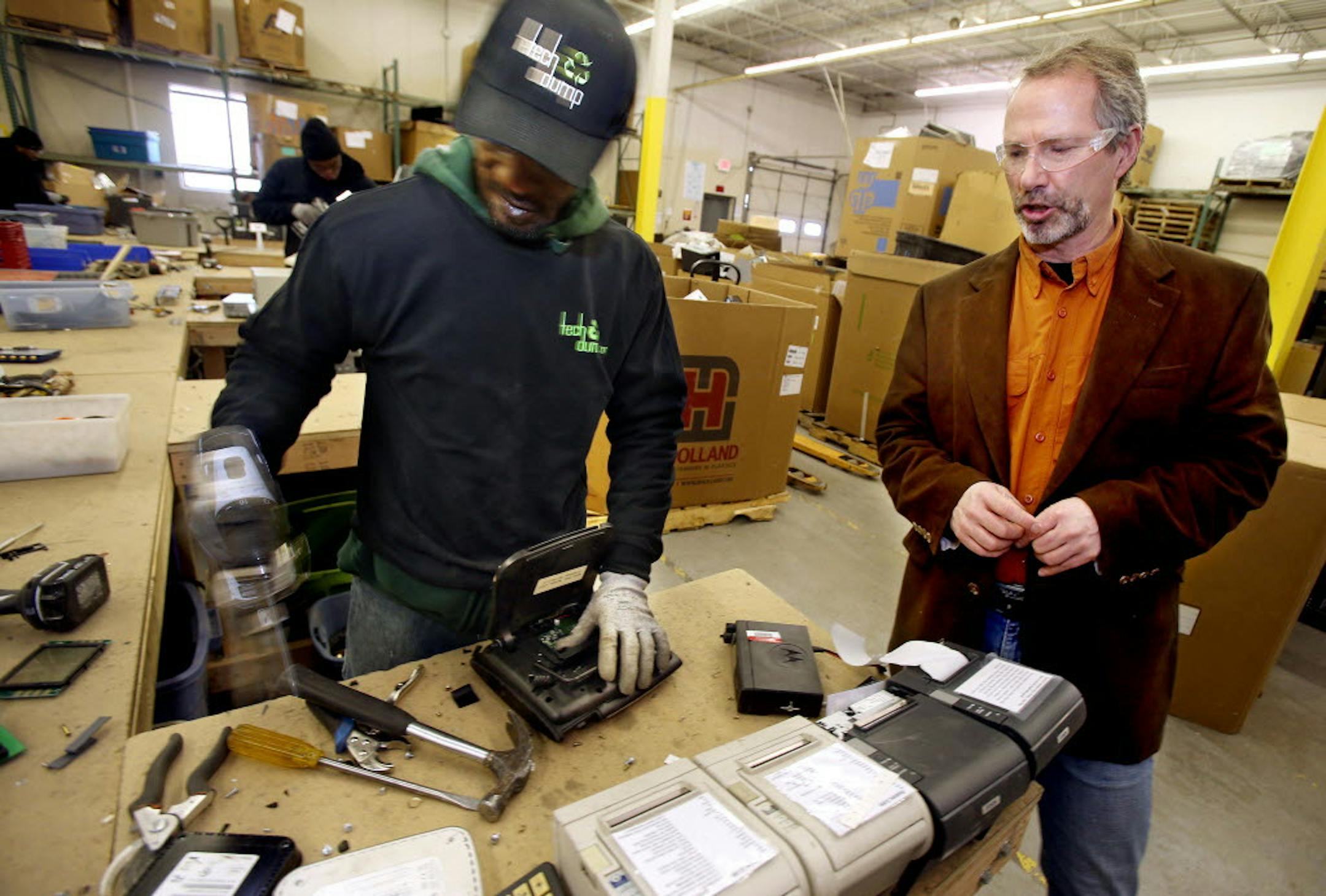 Tech Dump Executive Director Tom McCullough (right) spoke with Ben Johnson about computer parts at the Golden ValleyTech Dump plant in 2014. JOELKOYAMAïjkoyama@startribune