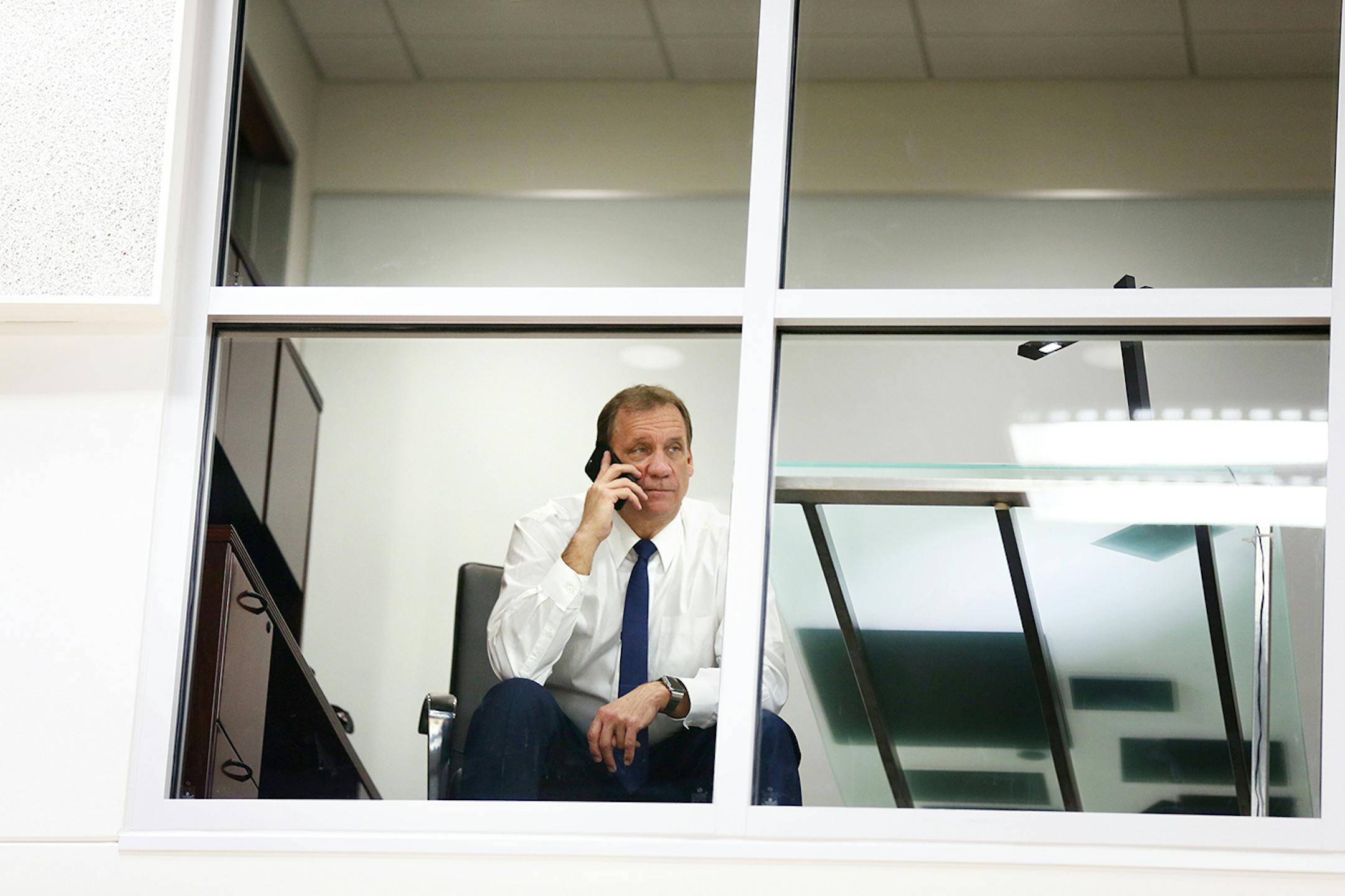 Timberwolves coach Flip Saunders talks on the phone inside his new office after the grand opening event at the Timberwolves and Lynx Courts at Mayo Clinic Square in downtown Minneapolis on Wednesday, June 17, 2015.