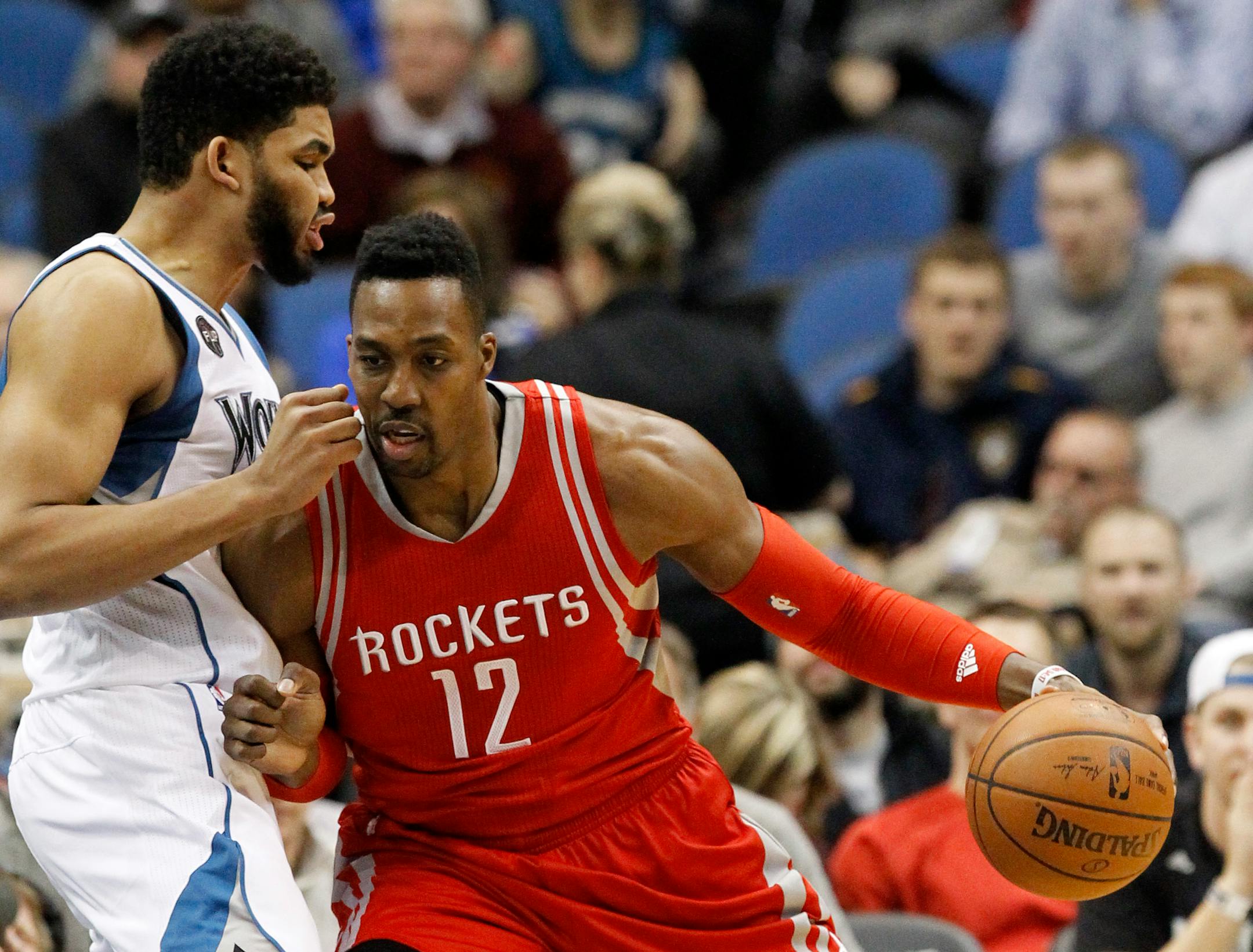 Houston Rockets center Dwight Howard, right, drives against Minnesota Timberwolves center Karl-Anthony Towns, left, during the first half of an NBA basketball game in Minneapolis, Monday, April 11, 2016.