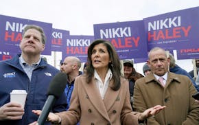 Republican presidential candidate Nikki Haley, center, addresses journalists while standing with New Hampshire Gov. Chris Sununu, left, and retired U.