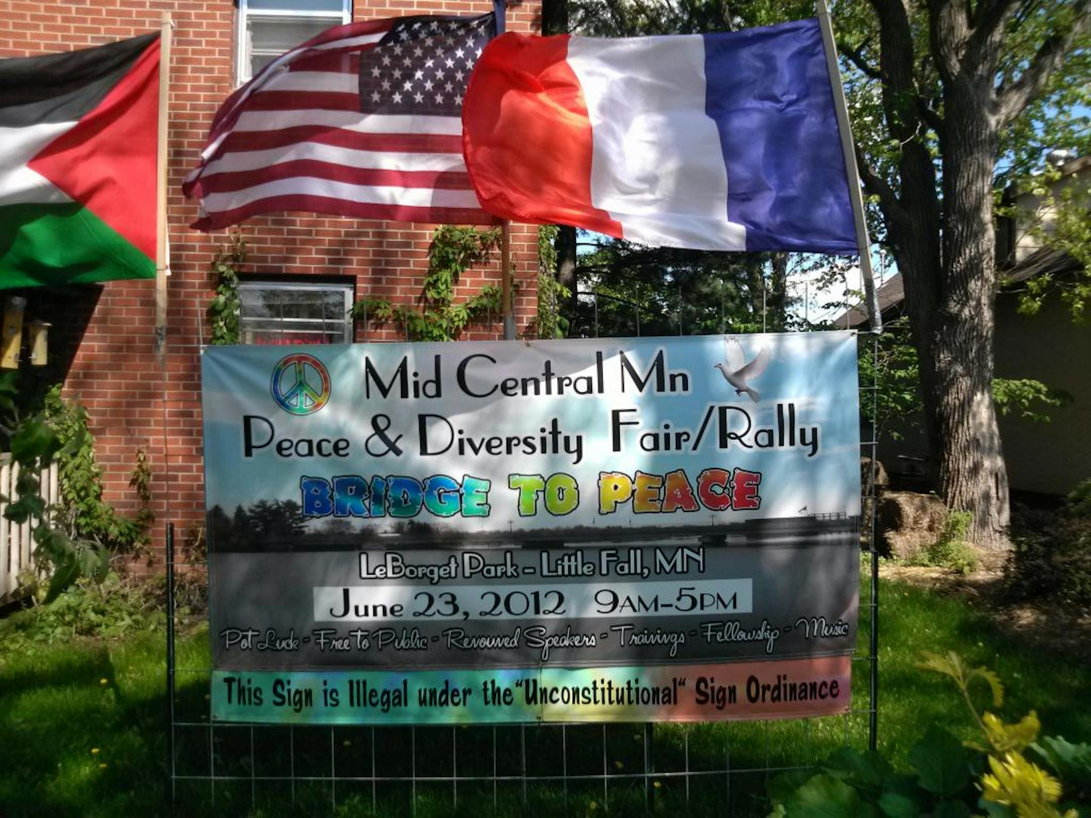Attorney Larry Frost and peace activist Robin Hensel sued the City of Little Falls on Monday. Above, a banner at her home.