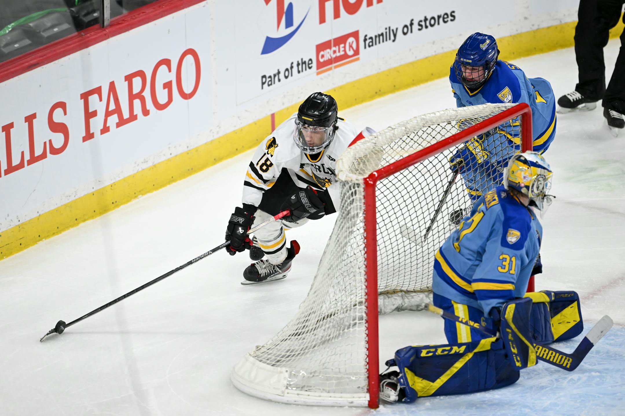 Warroad forward Carson Pilgrim (18) cuts behind the net of St. Cloud Cathedral goaltender Nick Hansen (31) during the third period.
