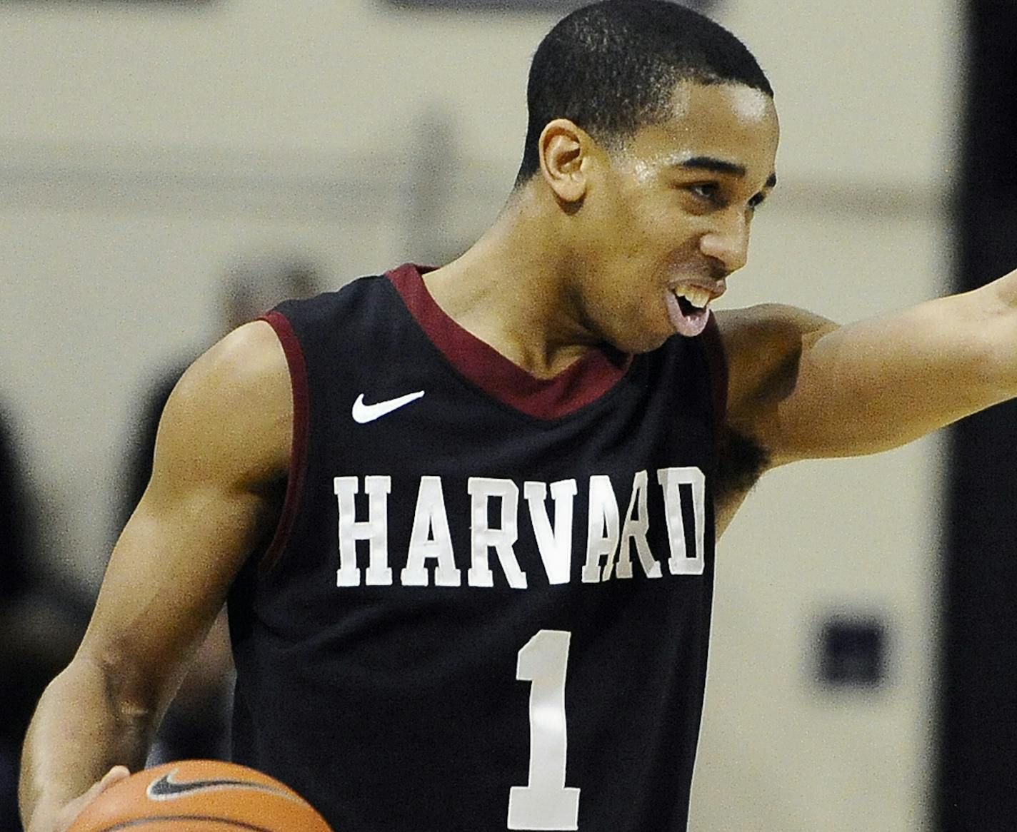 Harvard's Siyani Chambers, points and smiles at his team as he dribbles in the final seconds of an NCAA college basketball game against Yale, Friday, March 7, 2014, in New Haven, Conn. Harvard won 70-58. (AP Photo/Jessica Hill) ORG XMIT: CTJH110