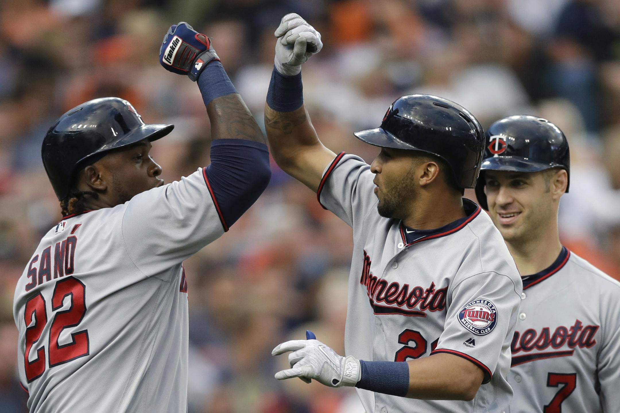Minnesota Twins' Eddie Rosario, center, is greeted by teammates Miguel Sano (22), and Joe Mauer (7) after his three-run home run during the fourth inning of the team's baseball game against the Detroit Tigers, Friday, Aug. 11, 2017, in Detroit. (AP Photo/Carlos Osorio)
