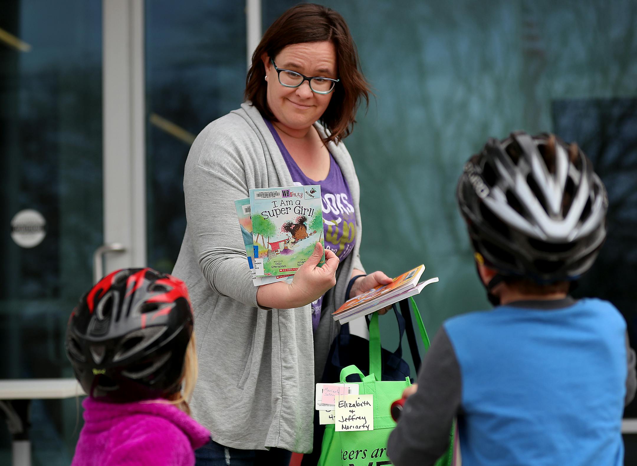 Lis Moriarty and her two children, Brenna, 4, and Liam, 5, walked from their home to the to the Ramsey County Library-Roseville, for curbside pickup and drop-off Thursday, April 23, 2020, in Roseville, MN. Members of the family are voracious readers and left with about 20 books for the week.] DAVID JOLES • david.joles@startribune.com No customer has stepped foot in a Ramsey County Library in a month but patrons are still checking out more than 1,000 books, magazines and DVDS each day than