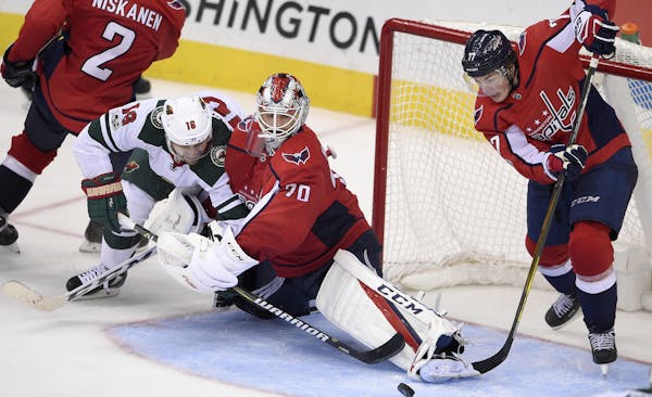 Minnesota Wild left wing Jason Zucker (16) battles for the puck against Washington Capitals goalie Braden Holtby (70) and right wing T.J. Oshie (77) d