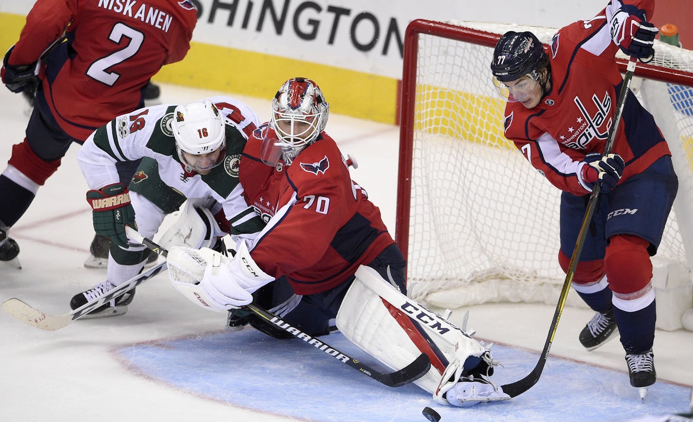 Minnesota Wild left wing Jason Zucker (16) battles for the puck against Washington Capitals goalie Braden Holtby (70) and right wing T.J. Oshie (77) during the third period of an NHL hockey game, Saturday, Nov. 18, 2017, in Washington. (AP Photo/Nick Wass)