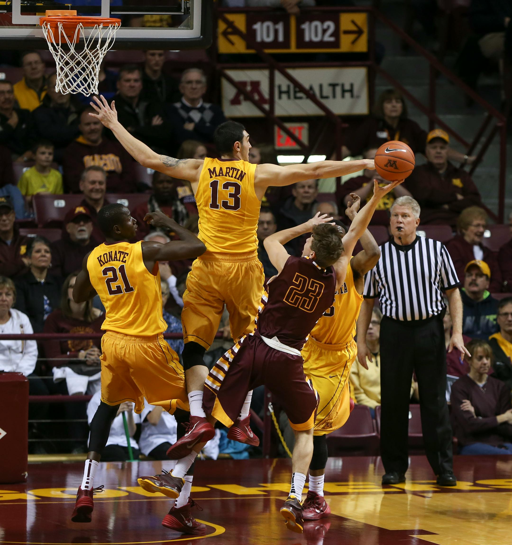 Taylor Lavery tried to get a shot off against the triple threat of the Gophers' Bakary Konate, Josh Martin, and Daquein McNeil, from left, in the first half Thursday night at Williams Arena.