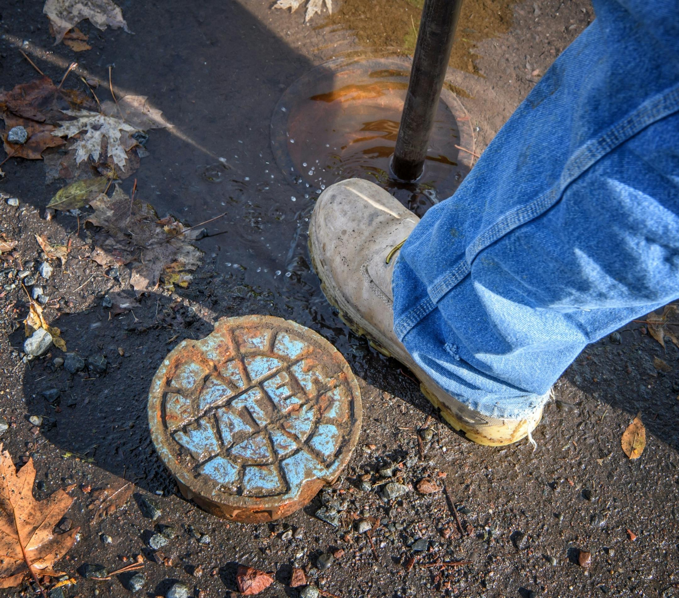 Josh Carlson closed a water valve. Josh Carlson and David Wuebkers are "leak seekers" part of Duluth's public works department who track leaks in the system.