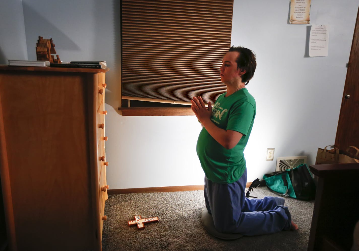 Aidan Spillane, 21, prayed before a crucifix in the townhouse where he has moved after spending nearly a year confined to a state mental hospital. Constant prayer is a source of comfort for his frequent anxiety.