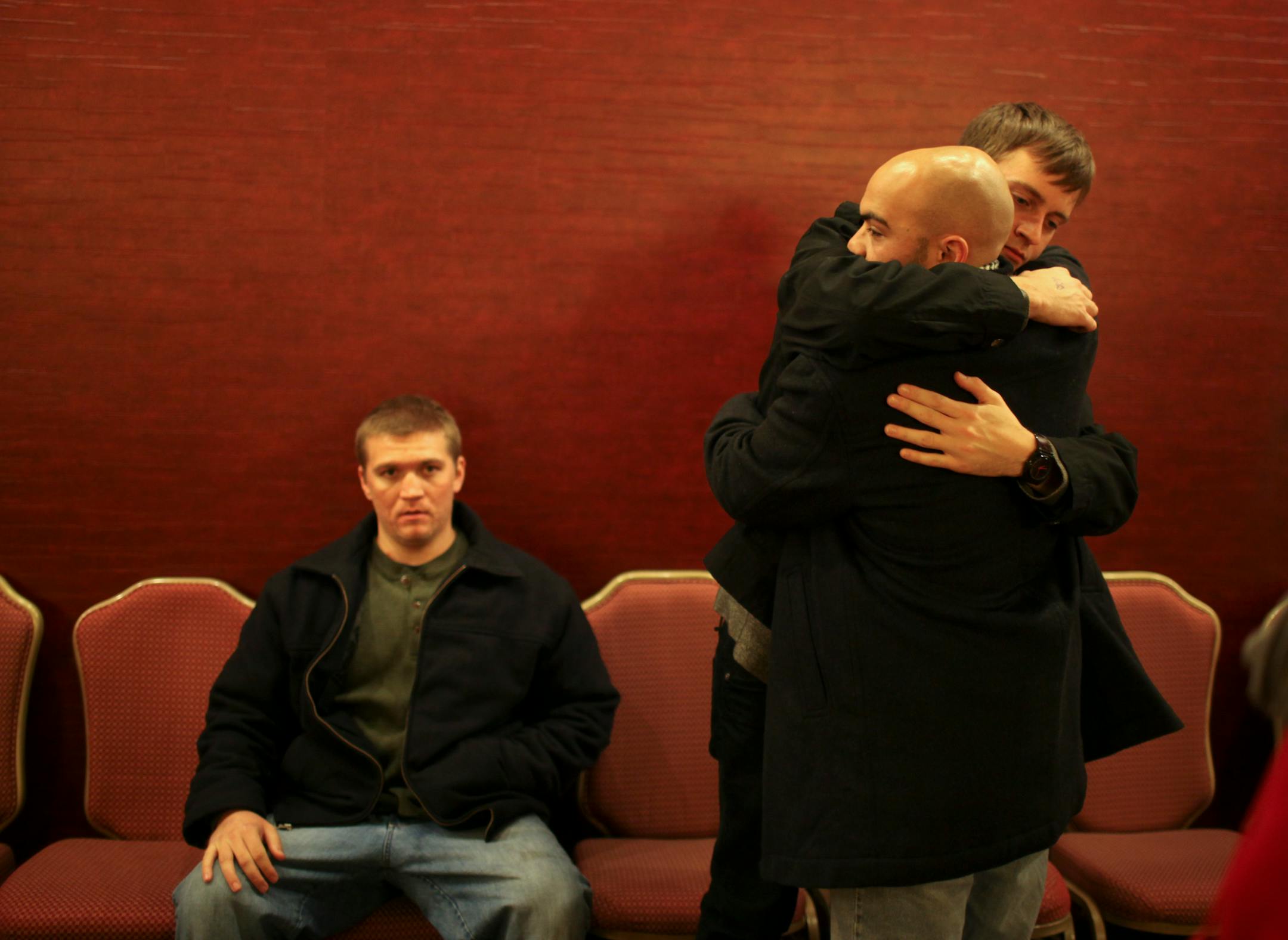 Jason McKenzie, facing camera, hugged George Miller when he arrived at the wake for Micheal Larsen Thursday night. McKenzie, who performs as Ecid, was mentored and had an album produced by Larsen. At left is performer Jordan Miché.