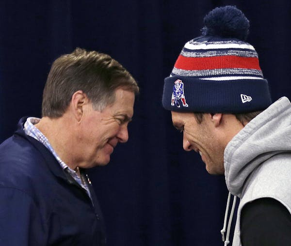 New England Patriots head coach Bill Belichick, left, and quarterback Tom Brady cross paths during a news conference before NFL football practice in F