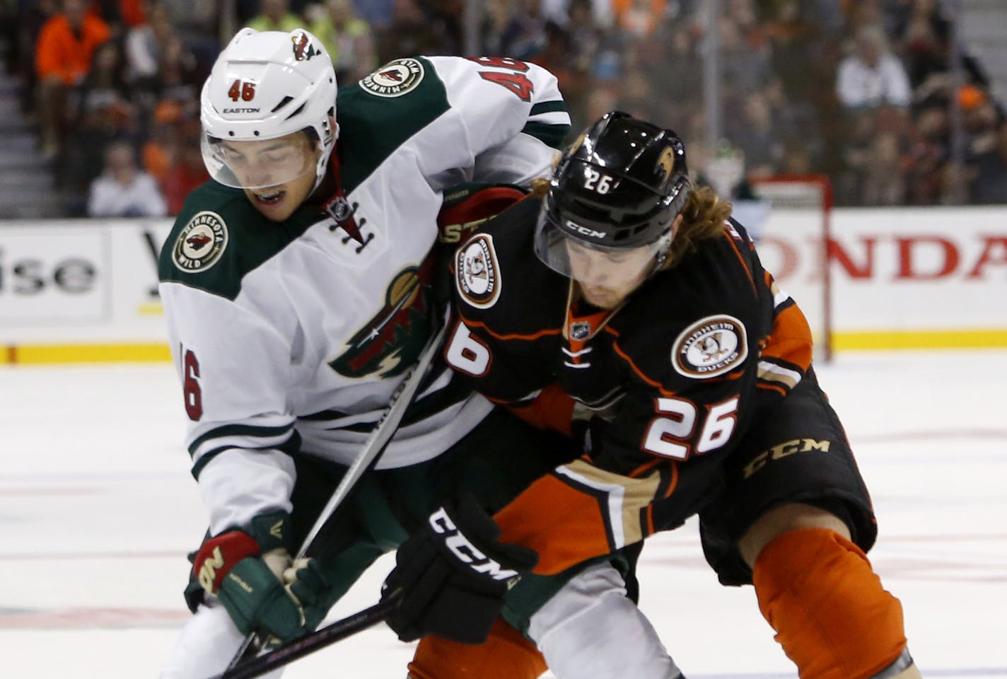 Minnesota Wild's Jared Spurgeon, left, and Anaheim Ducks' Carl Hagelin battle for the puck in the first period of an NHL hockey game in Anaheim, Calif., Sunday, Oct.18, 2015. (AP Photo/Christine Cotter)