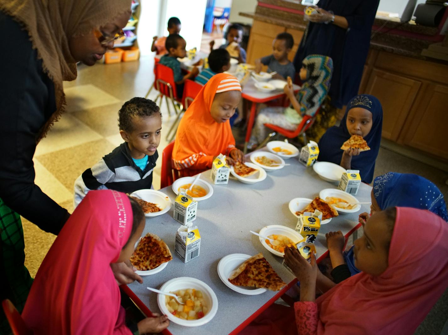 Prekindergarten children sat down to a dinner of fruit cocktail, pizza and milk at First Choice Child Care Center in Minneapolis.