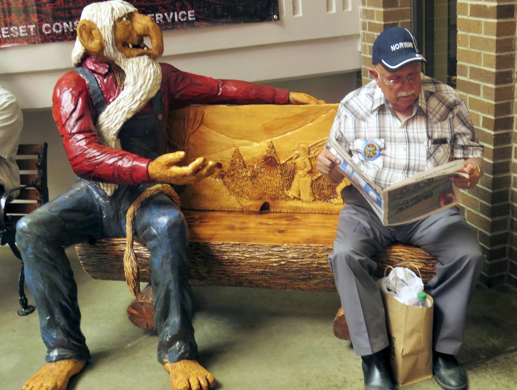 A bench with a chainsaw-carved troll invites visitors to rest at Hostfest.