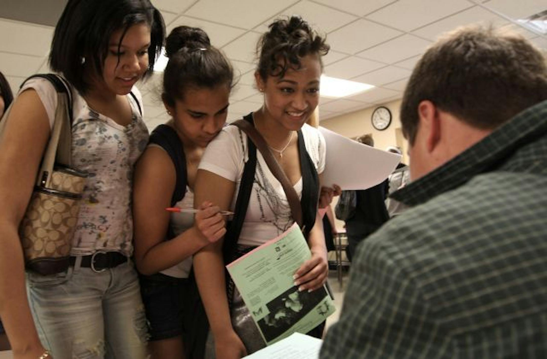 (left to right) St. Louis Park High School Juniors, Adrianna Breedlove, Raquel Uribe-Kauhaihao and Dalonda Gray stopped at the University of Minnesota station manned by Senior Alex Iordachi to learn more about the school during a Admission Possible program at the school. Admission Possible is in it's 10th year in the Twin Cities prepping kids for college.