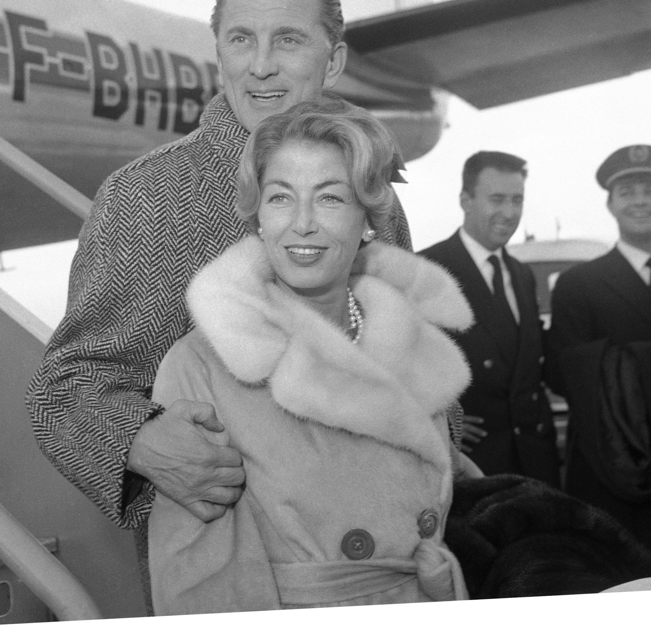 FILE - In this Dec. 5, 1960 file photo, actor Kirk Douglas and his wife Anne Douglas, formally Anne Buydens, arrive at London Airport from Paris to attend the premiere of his film, "Spartacus," in London. The ìSpartacusî star, who just turned 98-years-old, has 87 films to his name, 11 books, and is one of the last living members of old Hollywood. His new poetry collection ìLife Could Be Verse: Reflections on Love, Loss, and What Really Matters," in some ways, is his most personal
