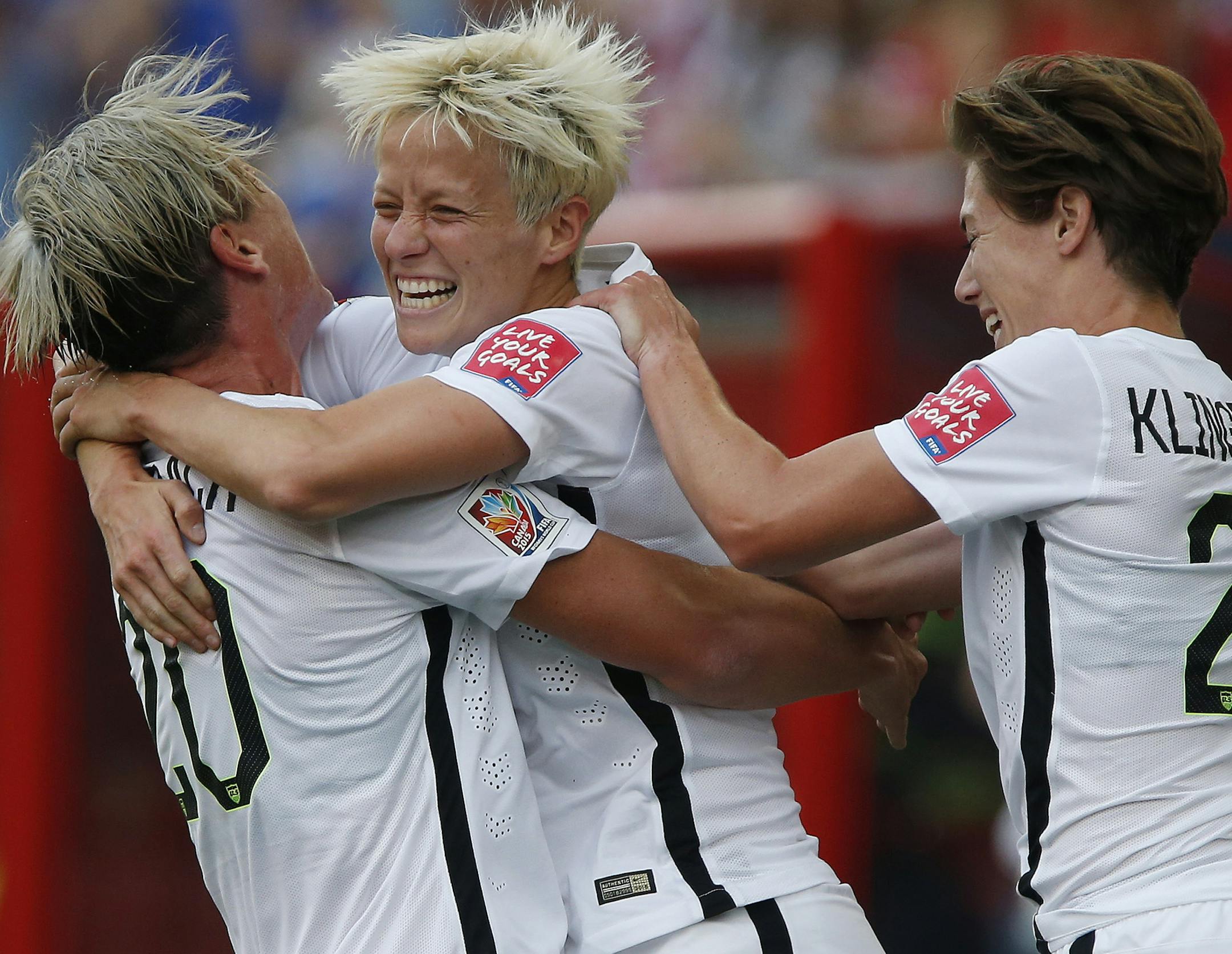 United States' Megan Rapinoe, center,, Abby Wambach (20) and Meghan Klingenberg (22) celebrate Rapinoe's goal against Australia during a FIFA Women's World Cup soccer match in Winnipeg, Manitoba, Monday, June 8, 2015. (John Woods/The Canadian Press via AP) MANDATORY CREDIT