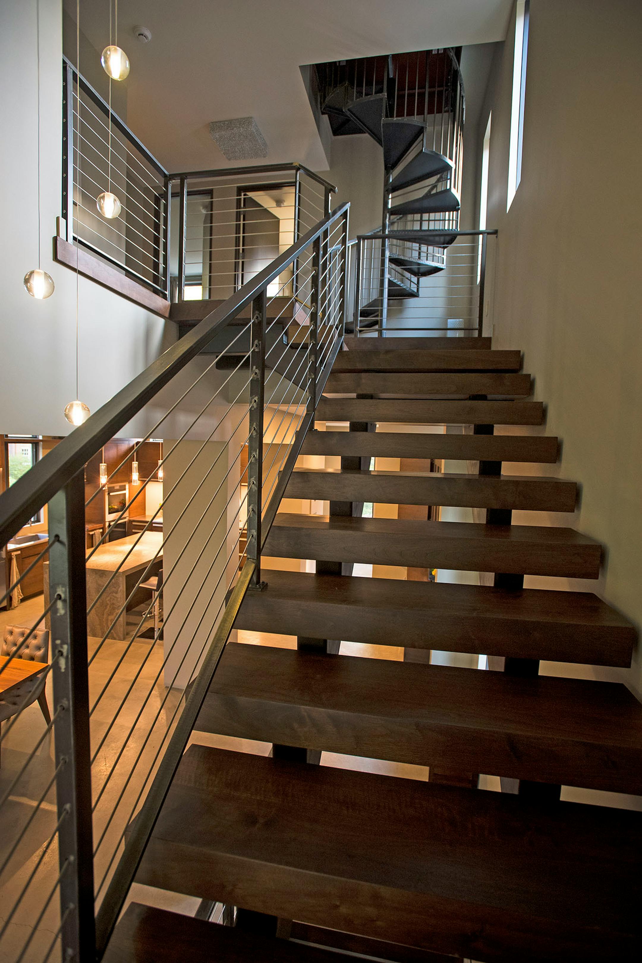 The industrial steel and wood open staircase leading to the upper-level.