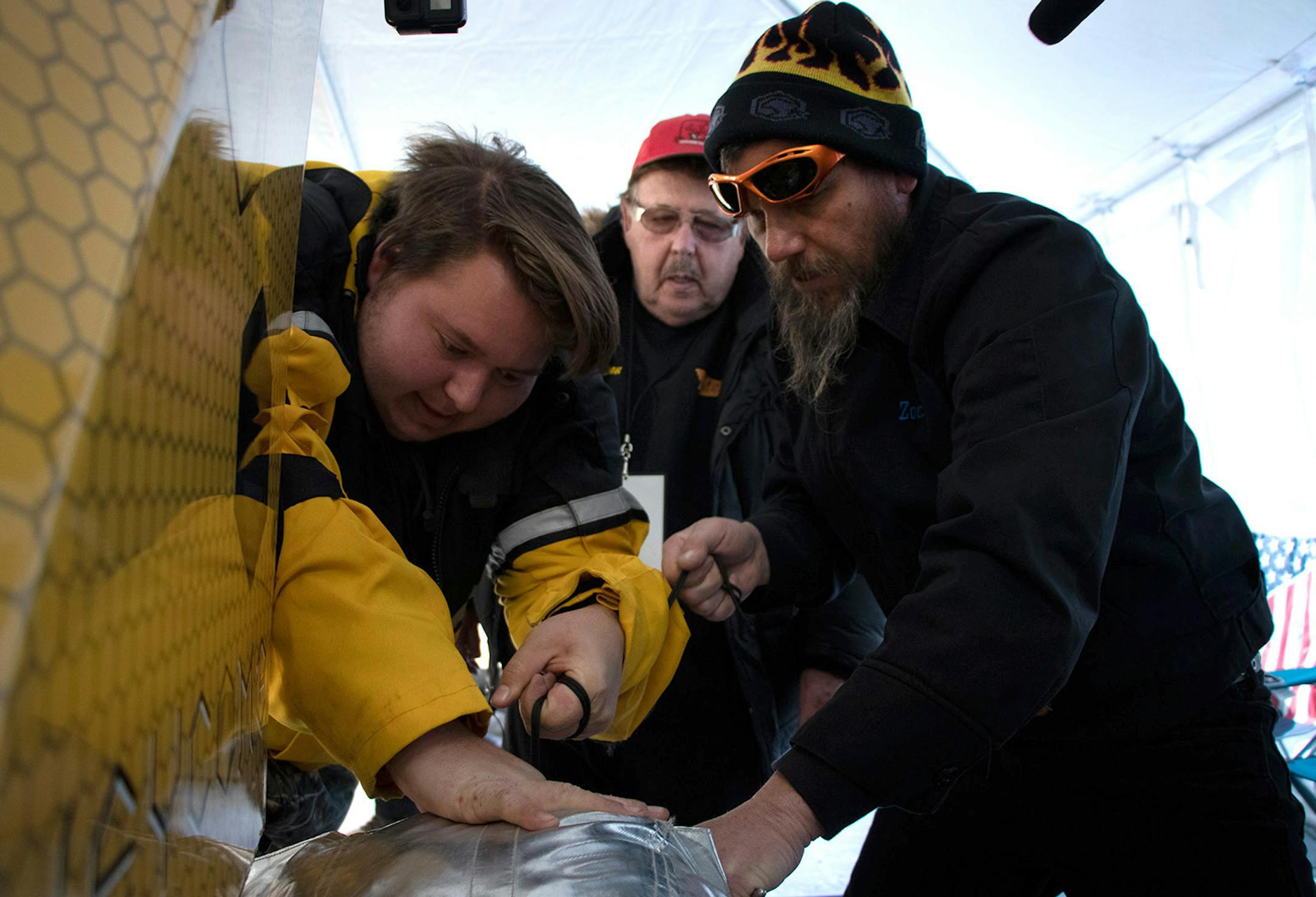 Buddy Michaelson, Ky Michaelson, and Kevin O�Kelly (left to right) pack the Arctic Arrow�s parachute before it�s first launch on Sunday, Feb. 16, 2020 on Bear Lake in Manawa, WI. The Arrow�s main braking system is the chute, with an ice claw ready to deploy for a quicker stop.