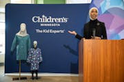 Henna & Hijabs CEO and founder Hilal Ibrahim gestures toward mannequins wearing modesty hospital gowns designed by her company, during a news conferen