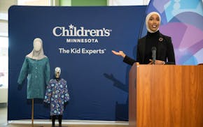 Henna & Hijabs CEO and founder Hilal Ibrahim gestures toward mannequins wearing modesty hospital gowns designed by her company, during a news conferen