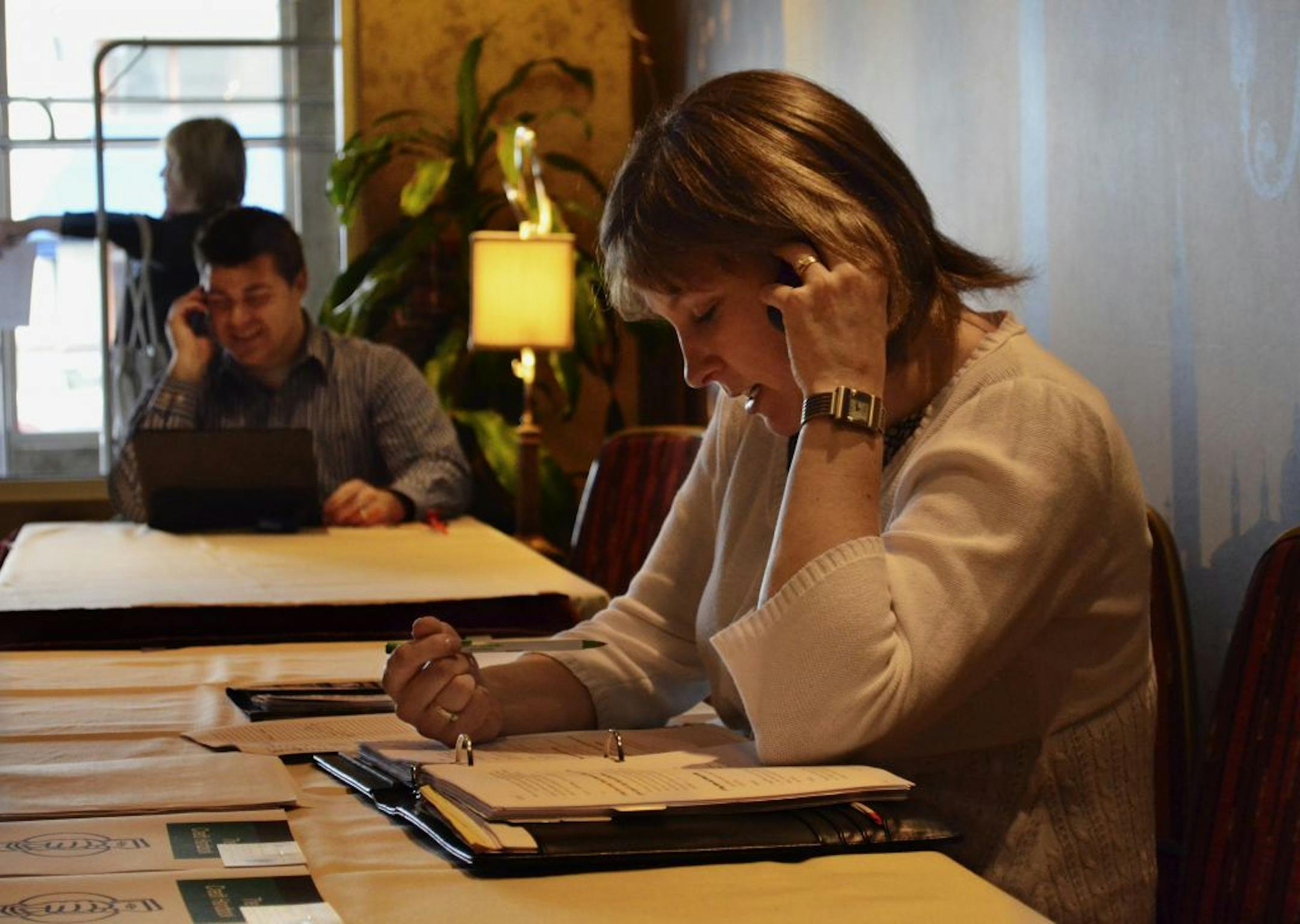 During a training session lecture break Deb Holmes sets up an appointment with a contact. Other Keller Williams agents can be seen in background doing the same.