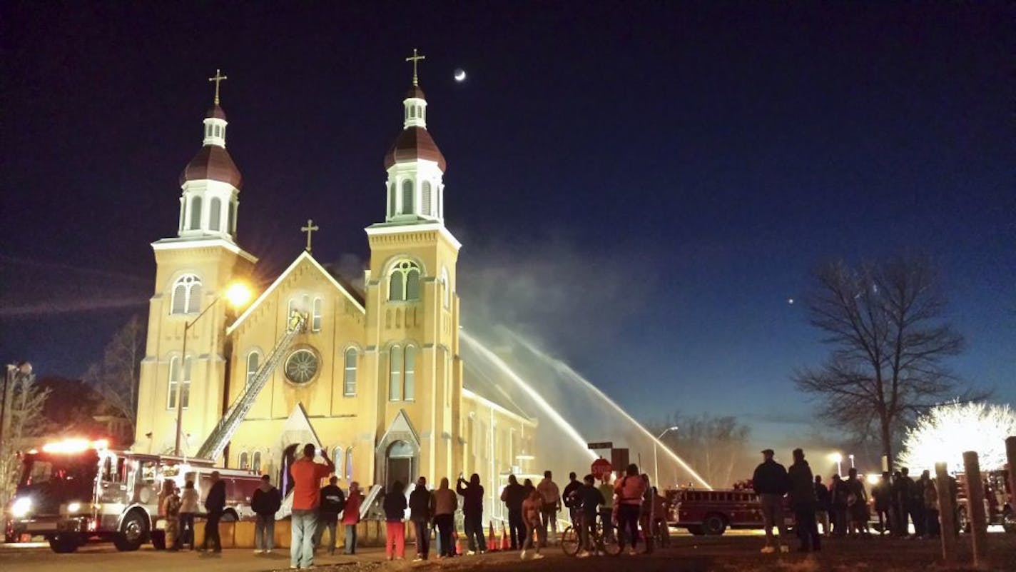 Crews from Sauk Centre, Melrose and Freeport battle a fire Friday, March 11, 2016, at the Church of St. Mary in Melrose, Minn. The fire has caused extensive damage to a historic church in central Minnesota. No one was hurt.