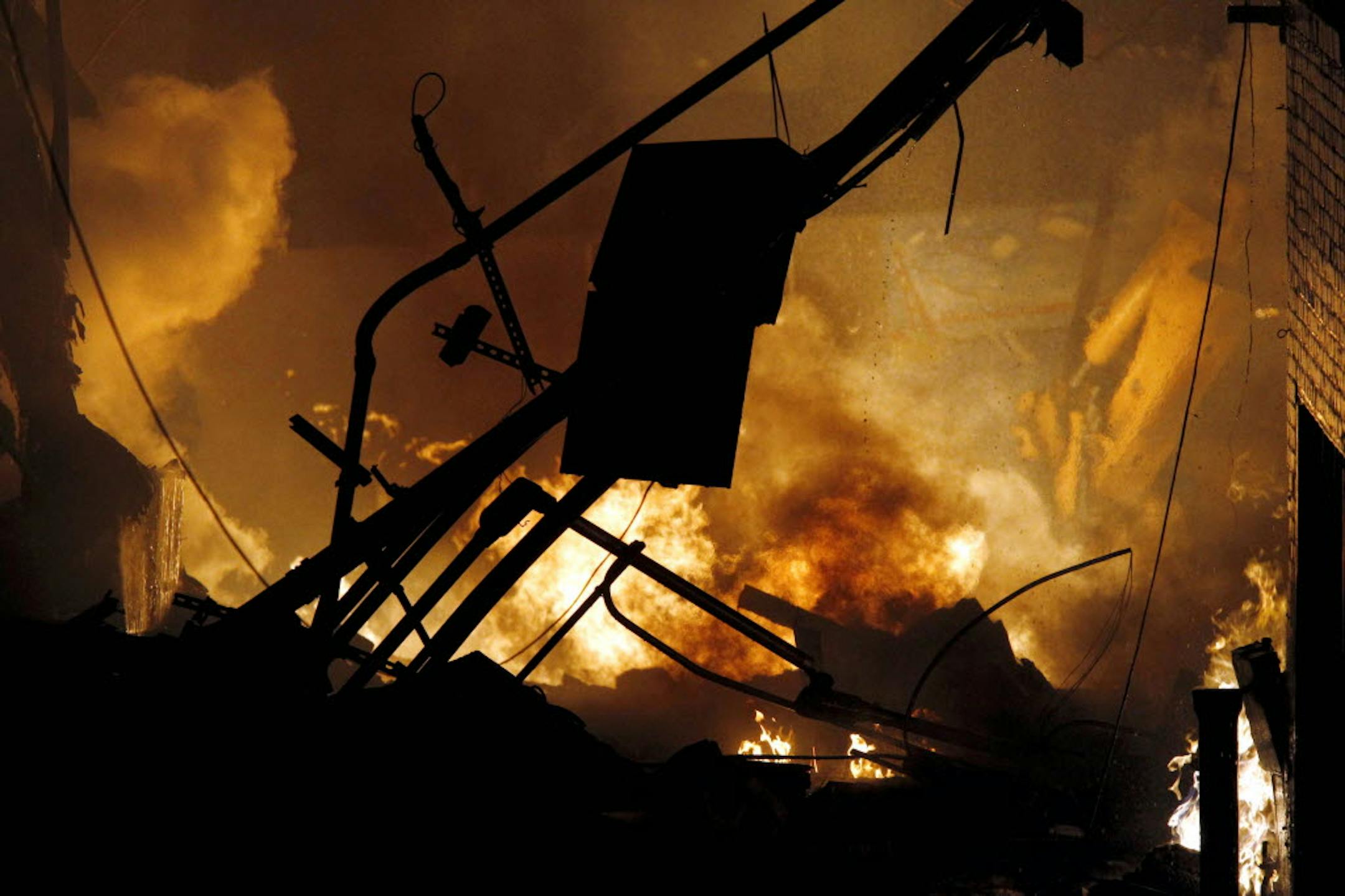 Fire and smoke rise at an upscale shopping district in Kansas City, Mo., where a city official said a gas explosion sparked a block-engulfing blaze.