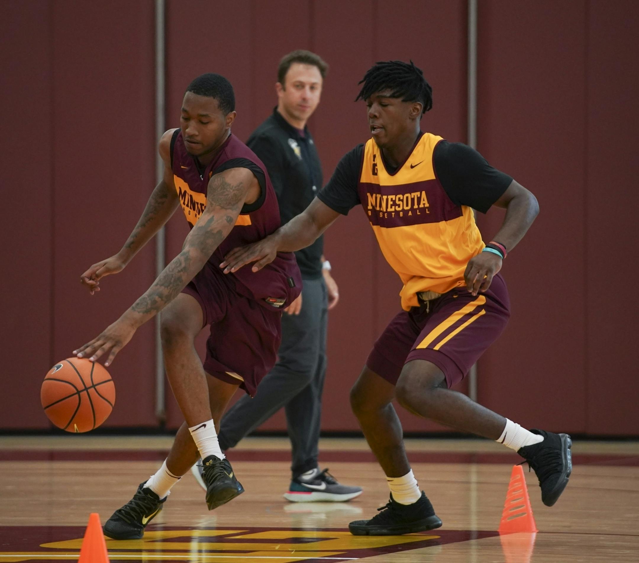 Dupree McBrayer, left, and Marcus Carr took part in a drill during practice Tuesday afternoon while head coach Richard Pitino observed.
