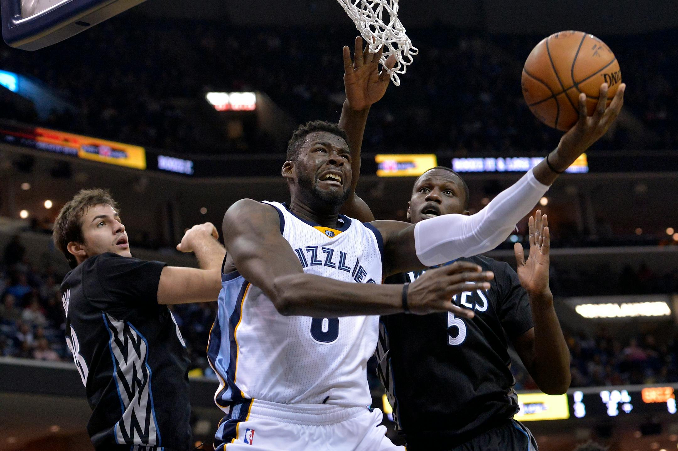 Memphis Grizzlies forward James Ennis, center, shoots between Minnesota Timberwolves forwards Gorgui Dieng (5) and Nemanja Bjelica (88) in the second half of an NBA basketball game Saturday, Nov. 19, 2016, in Memphis, Tenn. (AP Photo/Brandon Dill)