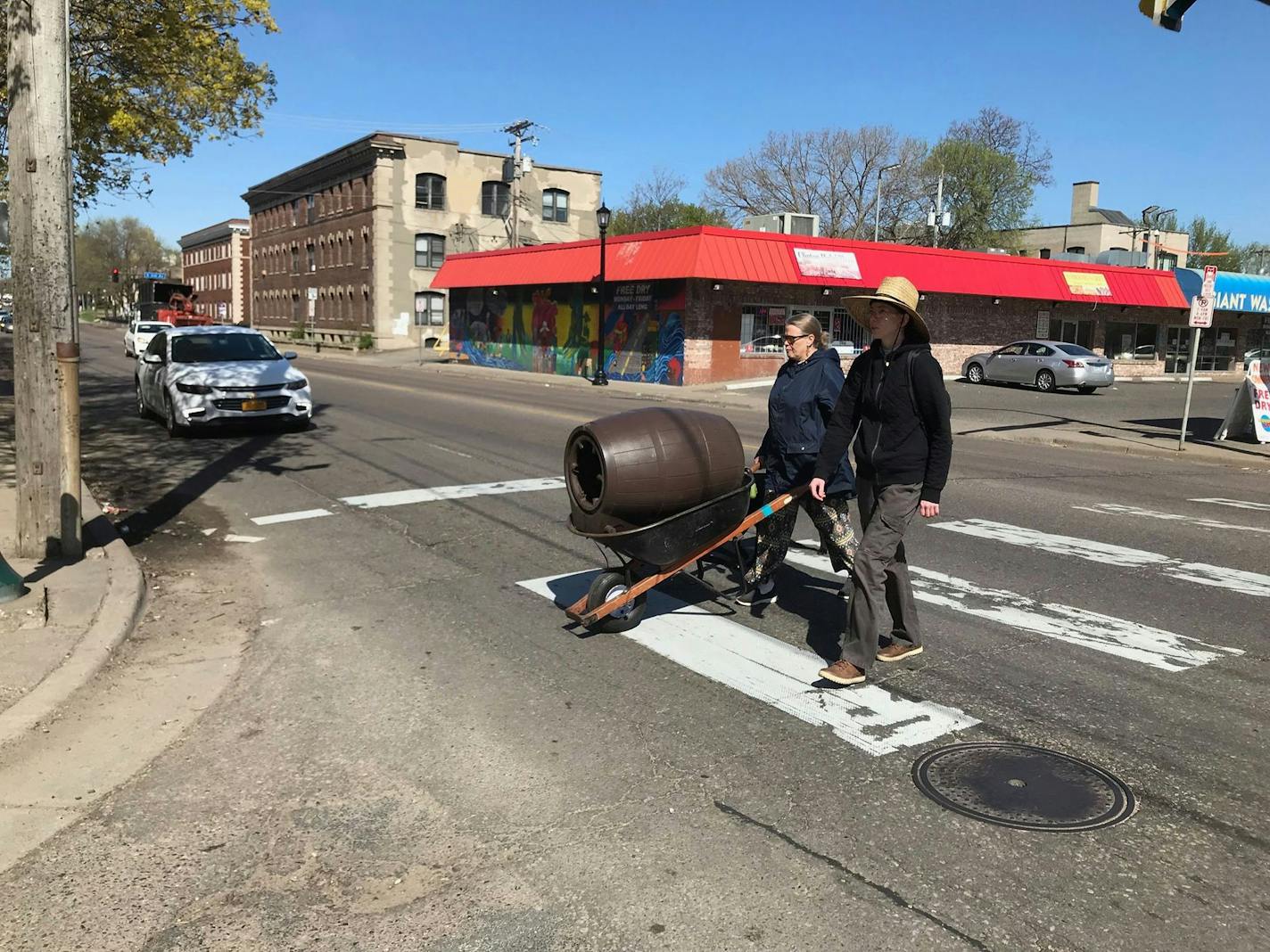 Cheryl Magnell, steward of the Emily Peake Memorial Garden, transports a rain barrel from the garden to another lot two blocks down on Tuesday, May 7, 2019. The owner of the Emily Peake property plans to turn the garden into a parking lot.