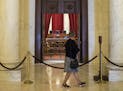 A visitor passes the courtroom of the Supreme Court in Washington, Oct. 4, 2016. The Supreme Court is begins its new term as it ended the last one, do