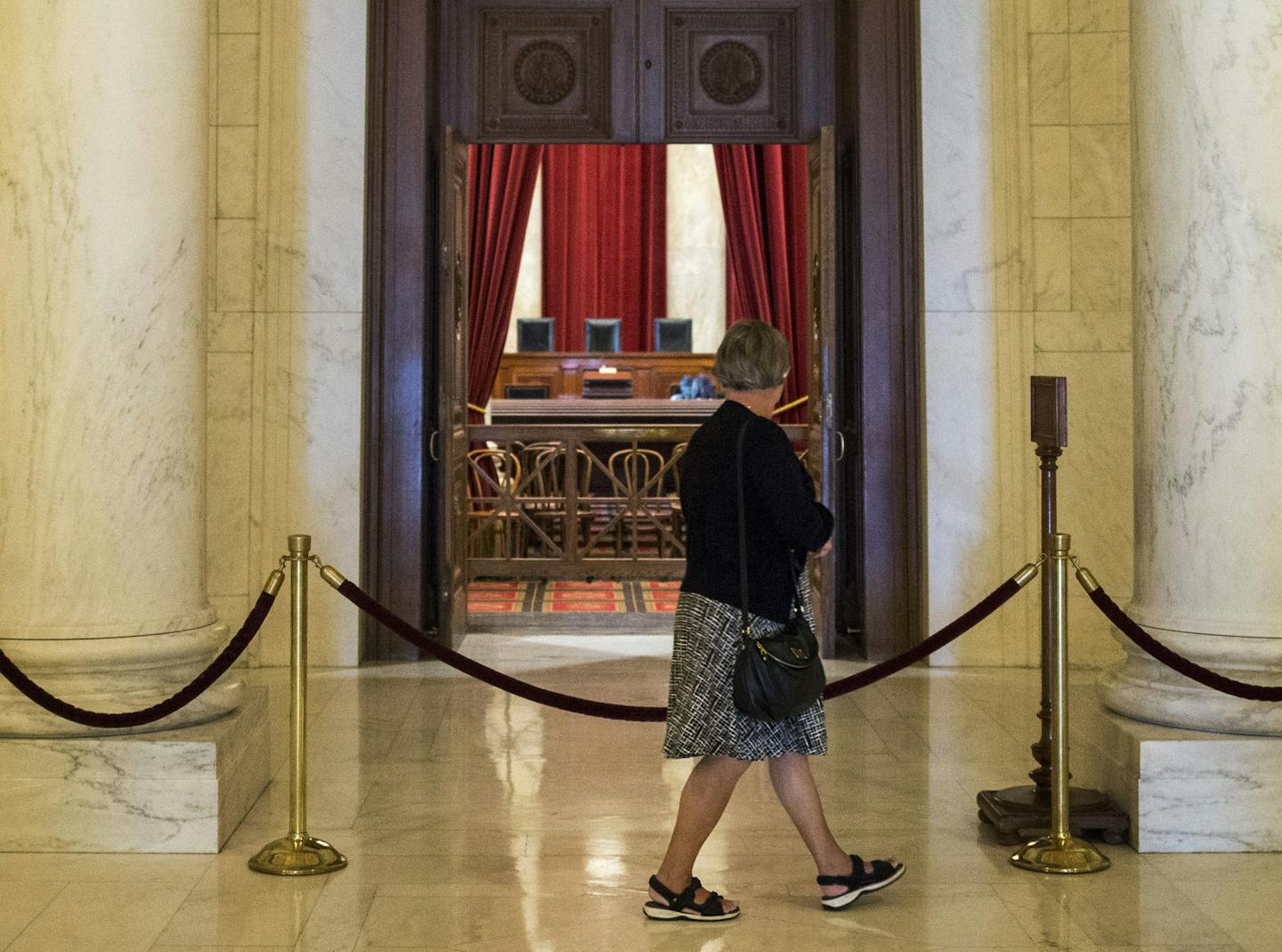 A visitor passes the courtroom of the Supreme Court in Washington, Oct. 4, 2016. The Supreme Court is begins its new term as it ended the last one, down one justice and ideologically deadlocked on a range of issues. The absence of a ninth justice since Antonin Scalia&#xed;s death in February has hamstrung the court in several cases and forced the justices to look for less contentious issues on which they are less likely to divide by 4-4 votes. (Al Drago/The New York Times) ORG XMIT: MIN201610271