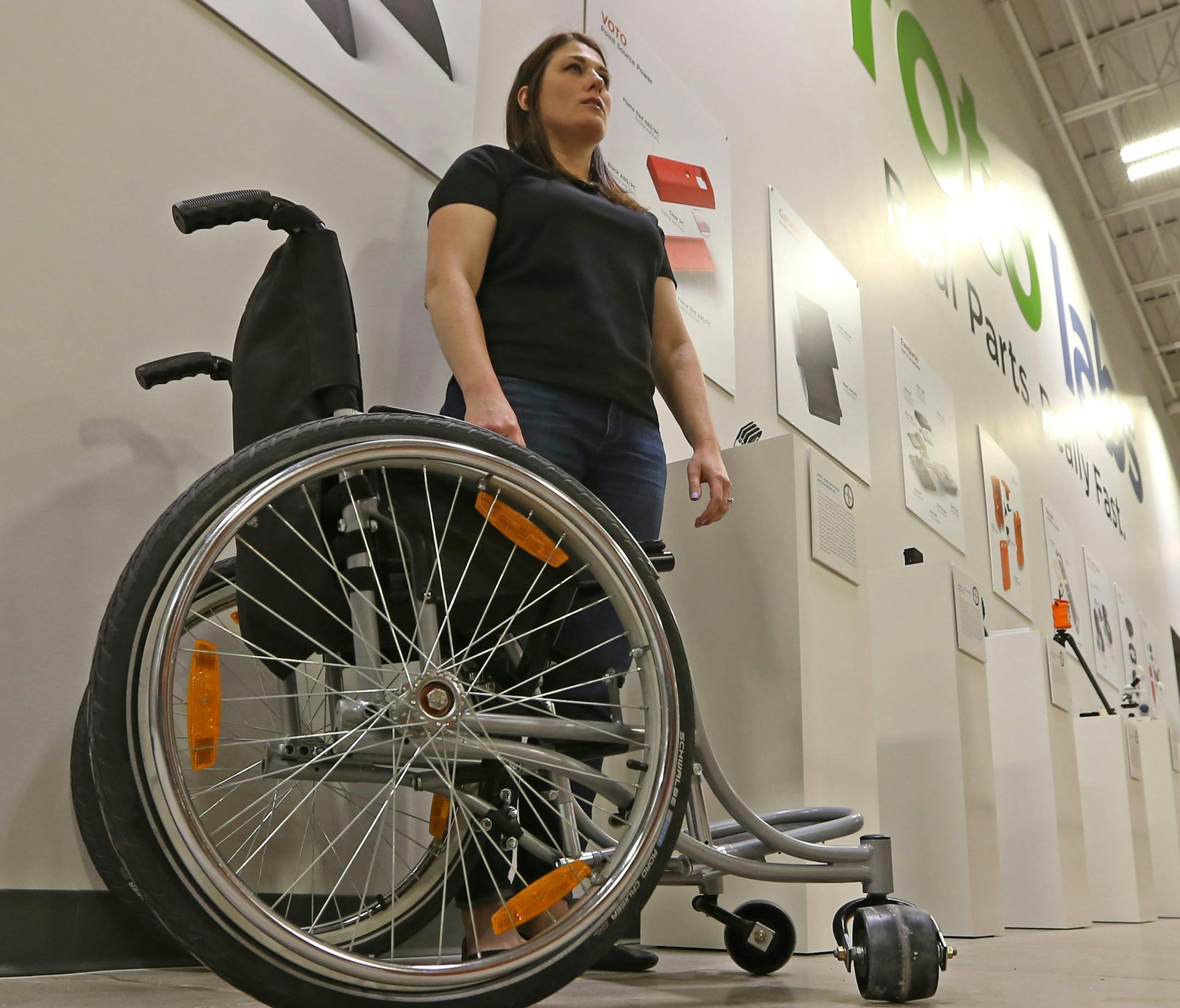 (left to right) Proto Labs Marketing Program Manager, Sarah Braun talked about the Rough Rider wheelchair, that Proto worked on, during an open house and tour of the new facility Plymouth facility, on 4/24/14. Proto Labs opens its new $15 million plant in Plymouth on Thursday. New CEO Vicki Holt will be there and be interviewed. New plant will get 100 new workers and is the company's 5th manufacturing plant.] Bruce Bisping/Star Tribune bbisping@startribune.com Sarah Braun, Mike Kenison, Vicki Ho