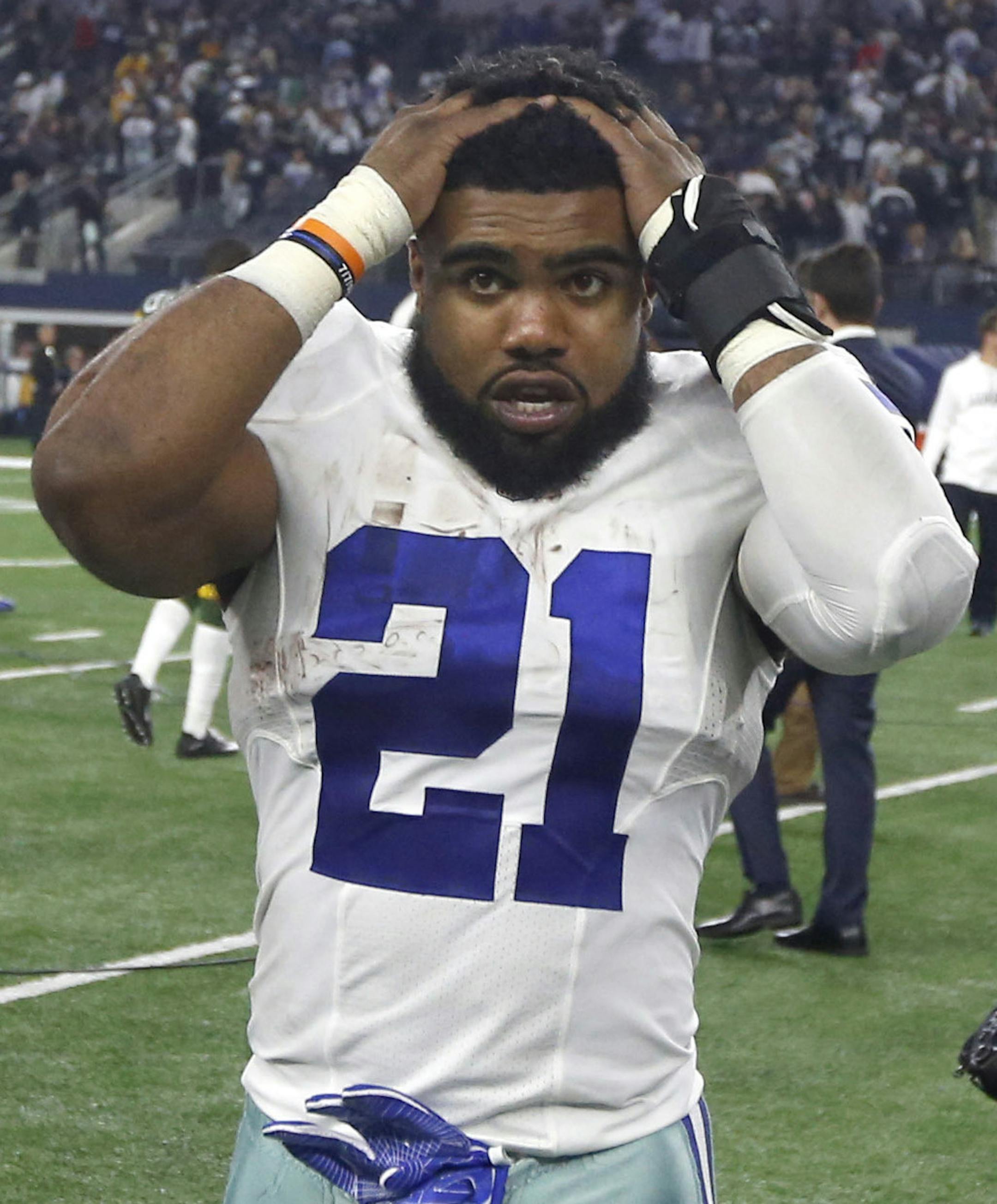 Dallas Cowboys' Ezekiel Elliott (21) and Jeff Heath (38) walk off the field after losing to the Green Bay Packers in an NFL divisional playoff football game Sunday, Jan. 15, 2017, in Arlington, Texas. The Packers won 34-31. (AP Photo/Michael Ainsworth)