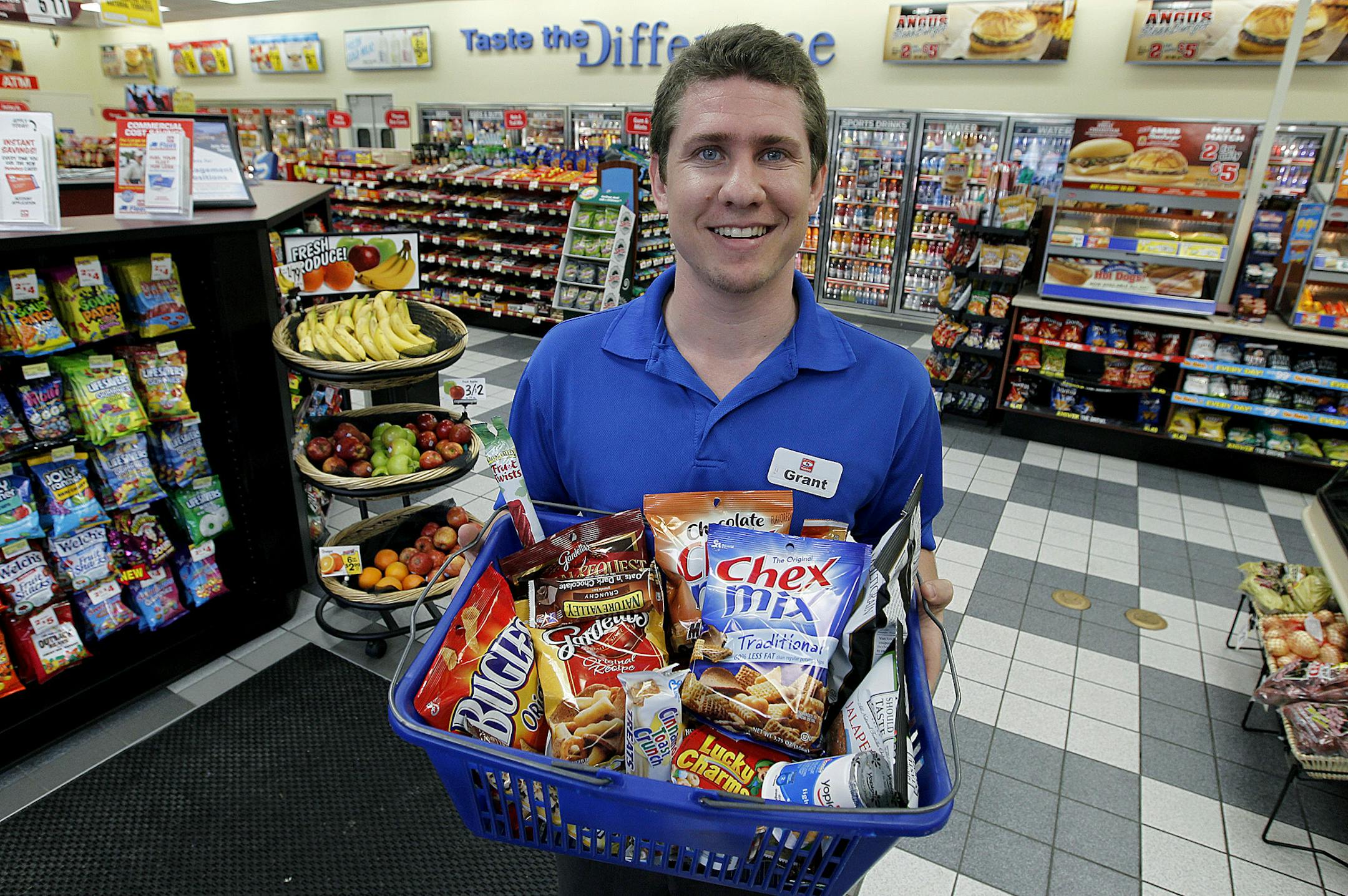 Grant Jacobs, a sales associate at a Holiday convenience store, held up a basket of popular General Mills snacks at the Plymouth, MN store, Wednesday, May 22, 2013. (ELIZABETH FLORES/STAR TRIBUNE) ELIZABETH FLORES • eflores@startribune.com