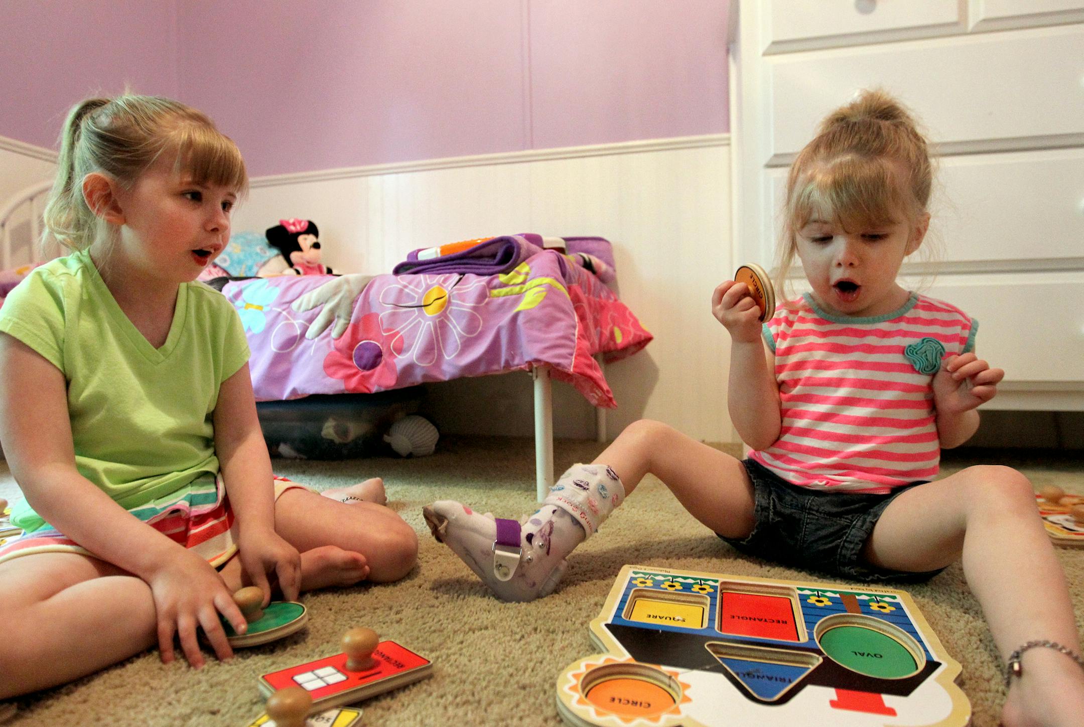 Sisters Madison, 7, left, and Sydney Rippy, 4, play at their home in Blaine, Minn., on Tuesday, July 9, 2013. Both girls had heart transplants when they were 3 years old after being diagnosed with cardiomyopathy, a rare condition that impedes the heart's ability to pump blood efficiently. ] (ANNA REED/STAR TRIBUNE) anna.reed@startribune.com (cq)